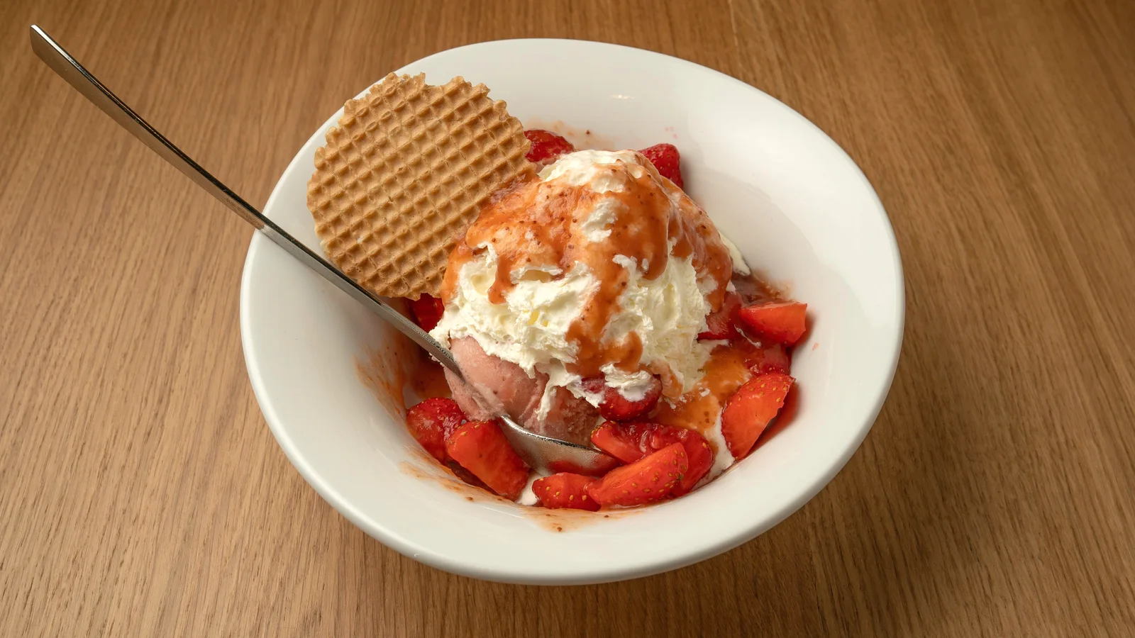 Erdbeer-Eisbecher mit Sahne, frischen Erdbeeren und Waffel